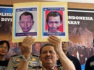Cảnh sát Indonesia đang giơ hình ảnh hai nghi can khủng bố vừa bắt giữ.