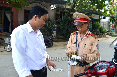 Thượng sĩ Bùi Thanh Nam kiểm tra giấy phép lái xe của người điều khiển phương tiện tham gia giao thông.
