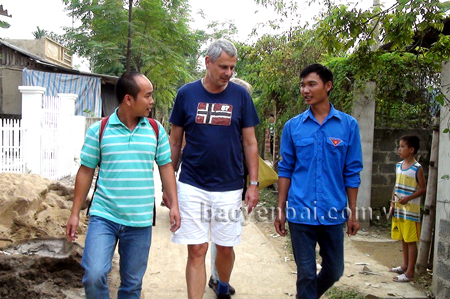 Anh Bình (bên phải) đưa khách nước ngoài đi thăm quan làng bản của đồng bào Thái ở Mường Lò.