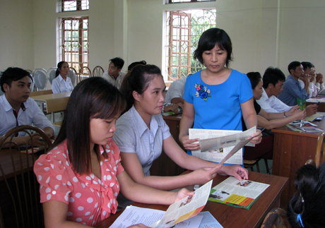 Cán bộ Sở Tư pháp phát tài liệu tuyên truyền pháp luật cho người dân tại xã Mông Sơn. 
