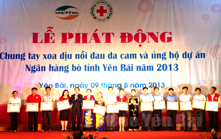 Các đồng chí lãnh đạo tỉnh trao bằng khen của UBND tỉnh cho các tập thể, cá nhân có thành tích xuất sắc tại Lễ phát động Chung tay xoa dịu nỗi đau da cam và ủng hộ Dự án Ngân hàng bò tỉnh Yên Bái năm 2013.
