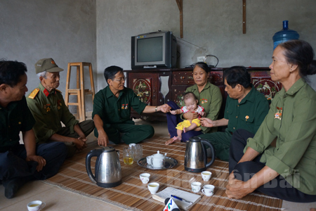 Cô Phạm Thị Thìn (người bế cháu bé) xúc động trong sự sẻ chia, thông cảm của đồng đội.