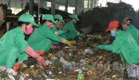 Công nhân Công ty cổ phần Môi trường và Năng lượng Nam Thành Yên Bái phân loại rác.