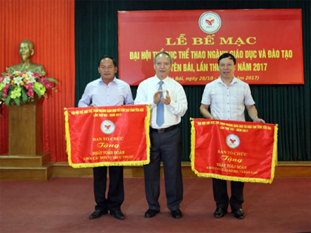 Ông Trần Xuân Hưng - Giám đốc Sở Giáo dục và Đào tạo tỉnh tặng cờ cho các đơn vị đạt giải nhất toàn đoàn tham dự Đại hội.
