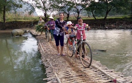 Hàng ngày, người dân thôn Loong Xa vẫn qua suối trên chiếc bè tạm bợ, nguy hiểm.