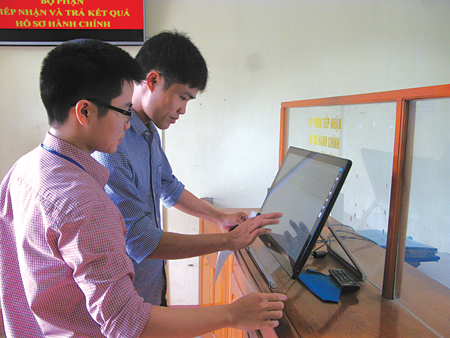 Người dân tra cứu thông tin trên bảng điện tử tại bộ phận tiếp nhận và trả kết quả của huyện Văn Yên.