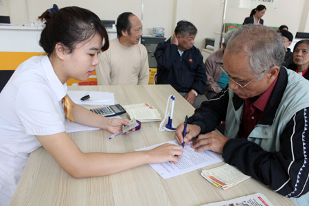 Nhân viên Bưu điện huyện Yên Bình hướng dẫn người dân kê khai thông tin trên mẫu phiếu TK01.