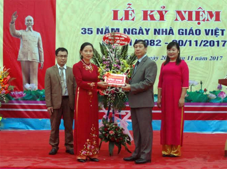 Đồng chí Nguyễn Văn Lịch -  Trưởng ban Nội chính Tỉnh ủy trao tặng hoa và quà chúc mừng thầy và trò các trường học xã Động Quan, huyện Lục Yên.