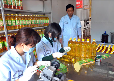 Dán nhãn sản phẩm dầu lạc tại HTX Thái Sơn, huyện Lục Yên.