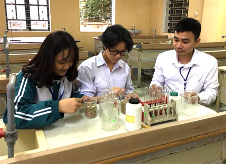 Thầy giáo Nguyễn Anh Đức cùng học sinh nghiên cứu quá trình ủ phân bón hữu cơ từ vỏ lạc.