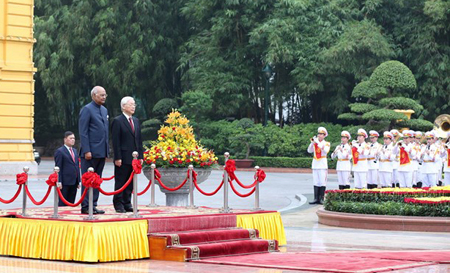 Tổng Bí thư, Chủ tịch nước Nguyễn Phú Trọng và Tổng thống Ấn Độ Ram Nath Kovind trên bục danh dự, nghe Quân nhạc cử Quốc thiều hai nước.