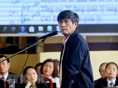 Bị cáo Nguyễn Thanh Hóa xem các văn bản là tang vật của vụ án được chiếu trên màn hình.