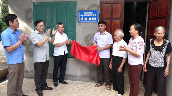 Lãnh đạo thành phố Yên Bái gắn biển hỗ trợ làm nhà cho hộ nghèo tại xã Minh Bảo.