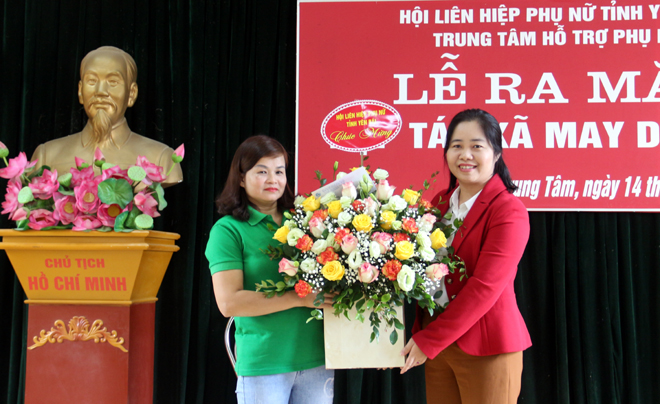 Bà Hà Thị Đóa – Phó Chủ tịch Hội LHPN tỉnh Yên Bái tặng hoa chúc mừng HTX May Duy Tiến.