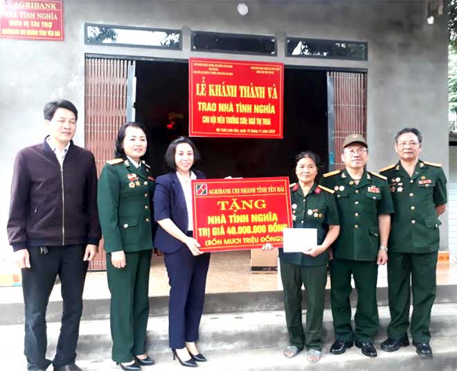Lãnh đạo Ngân hàng Nông nghiệp và Phát triển nông thôn Yên Bái cùng Hội Cựu thanh niên xung phong trao quà cho bà Ngô Thị Thoa nhân dịp bàn giao ngôi nhà mới.