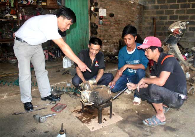 Cán bộ Trung tâm GDNN - GDTX huyện Trạm Tấu hướng dẫn học viên học nghề sửa chữa xe máy.