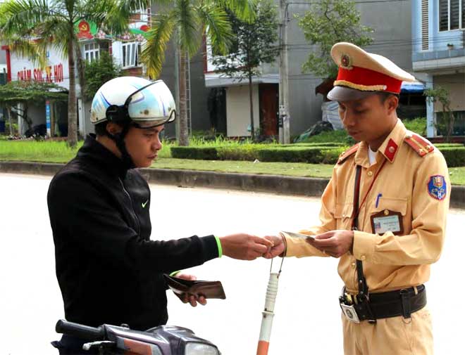 Cảnh sát giao thông huyện Yên Bình kiểm tra giấy tờ người điều khiển phương tiện tham gia giao thông.