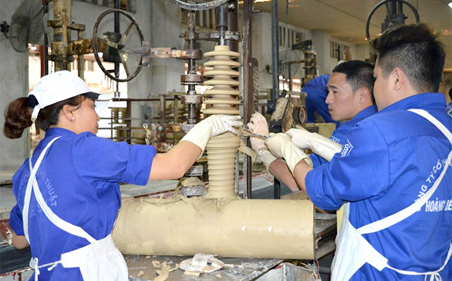 Workers at the Hoang Lien Son Ceramic Technical joint Stock Company make porcelain insulators.