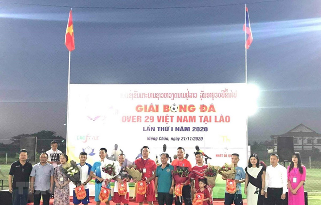 Đại diện Đại sứ quán Việt Nam tại Lào cùng các đại biểu tặng hoa và cờ lưu niệm cho tổ trọng tài và 7 đội tham dự giải.
