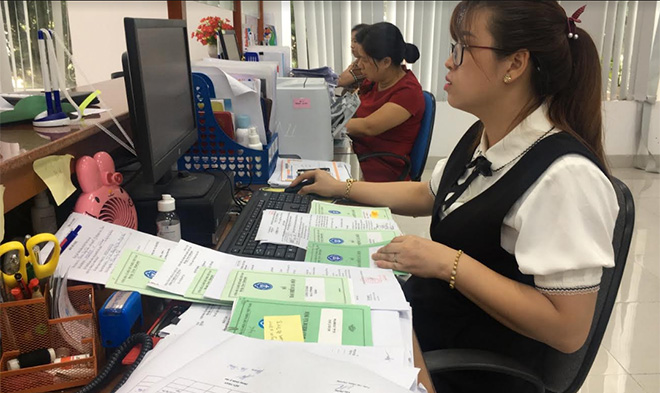 Cán bộ Bảo hiểm xã hội tỉnh Yên Bái chốt sổ bảo hiểm cho người lao động.