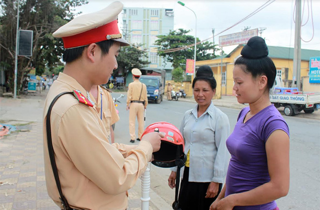 Đội Cảnh sát giao thông, Công an thị xã Nghĩa Lộ tuyên truyền cho người dân cách nhận biết mũ bảo hiểm đạt quy chuẩn.