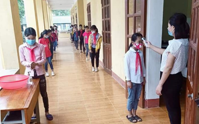 Học sinh Trường TH&THCS Liễu Đô, huyện Lục Yên được kiểm tra thân nhiệt, rửa tay sát khuẩn trước khi vào lớp.