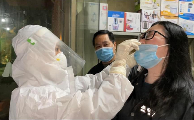 Cán bộ Trung tâm Y tế huyện Yên Bình lấy mẫu xét nghiệm sàng lọc, truy vết tại khu vực có bệnh nhân dương tính với SARS -CoV -2 ngay trong đêm 27/11. (Ảnh: FB Kiều Mười)