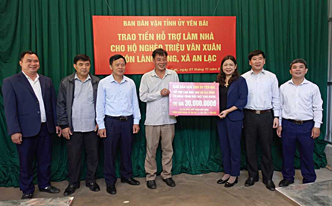 Trưởng Ban Dân vận Tỉnh ủy Hoàng Thị Vĩnh trao tiền hỗ trợ làm nhà ở cho ông Triệu Văn Xuân.