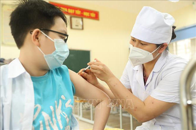 Nhân viên y tế quận Hà Đông (Hà Nội) tiêm vaccine phòng COVID-19 cho học sinh lớp 6 tại điểm tiêm chủng trường THCS Lê Quý Đôn. Ảnh tư liệu