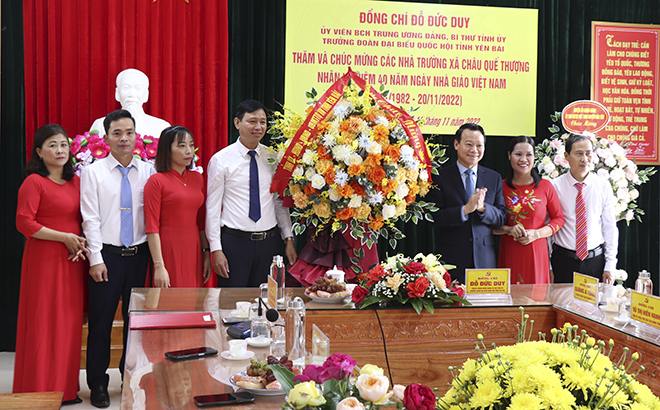Secretary of the provincial Party Committee Do Duc Duy presents flowers to teachers of the two schools in Chau Que Thuong commune.
