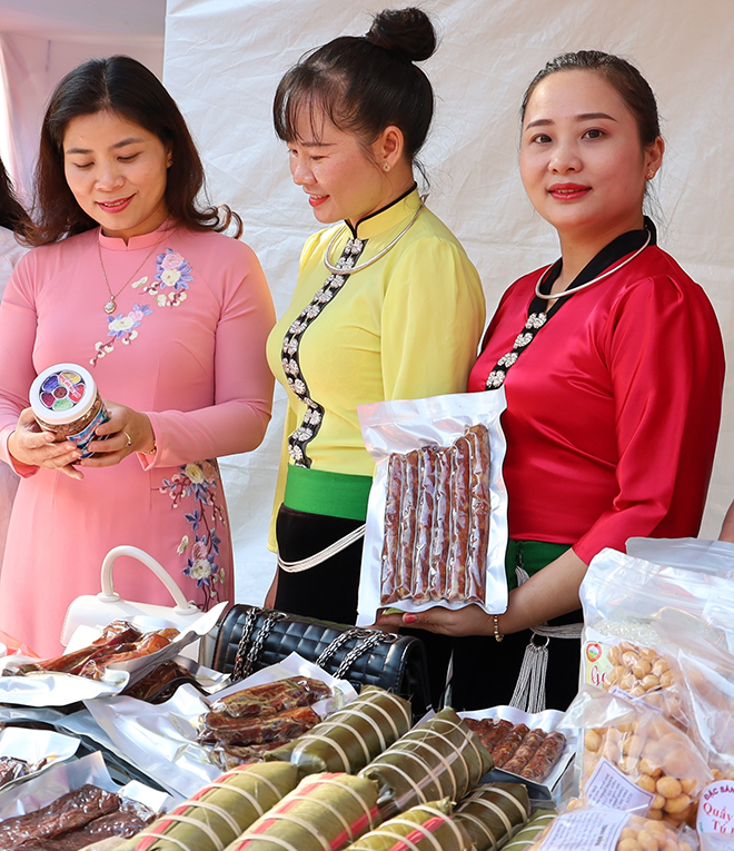 Luong Thi Hoan (right) introduces smoked meat at a stall popularising products of the VWU’s Nghia Lo town chapter during Women’s Entrepreneurship Festival 2022.
