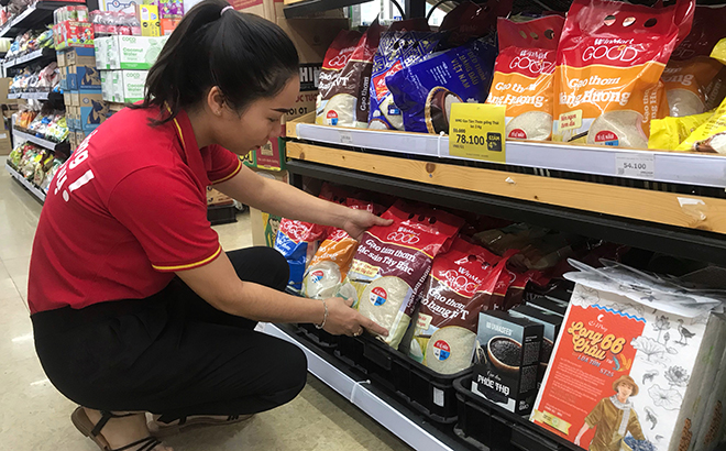 Nhân viên Cửa hàng Winmart+ số 2 đường Quang Trung, thành phố Yên Bái đang bày bán các sản phẩm gạo Việt Nam.