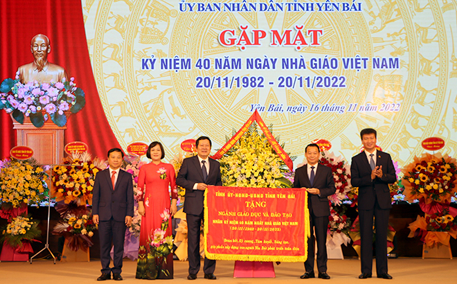 Secretary of the provincial Party Committee Do Duc Duy and Chairman of the provincial People's Committee Tran Huy Tuan present flowers and an embroidered flag bearing the words 