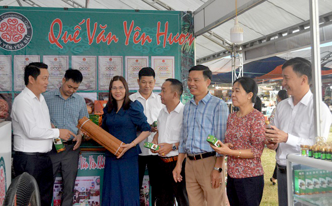 Lãnh đạo huyện Văn Yên và người dân thăm quan gian hàng trưng bày sản phẩm OCOP từ quế.