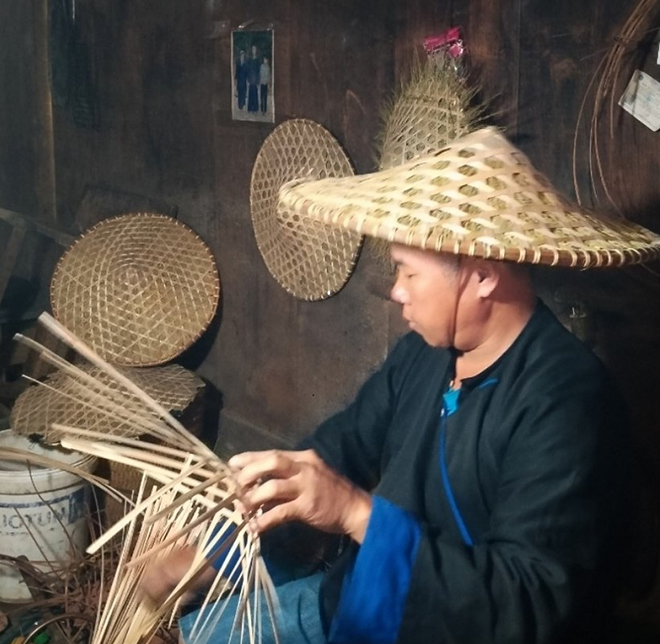 Anh Sùng A Pủa đang đan sản phẩm nón tre.
