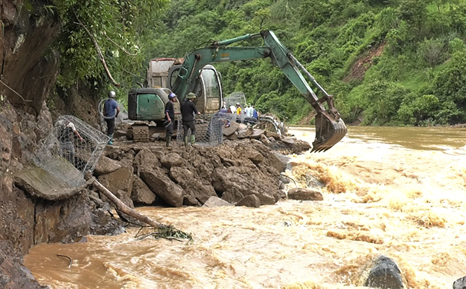 Công nhân Công ty cổ phần Xây dựng đường bộ I - Yên Bái nỗ lực san lấp mặt đường bị trận lũ ngày 5/8 cuốn trôi hoàn toàn tại Km 326+250, quốc lộ 32 đoạn qua huyện Mù Cang Chải.

