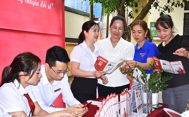 Cán bộ Ngân hàng Agribank Lục Yên hướng dẫn người dân thị trấn Yên Thế cài đặt ứng dụng thanh toán điện tử trên điện thoại thông minh.