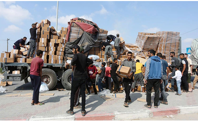 Người dân chuyển hàng cứu trợ nhân đạo tại cửa khẩu Rafah ở Dải Gaza.
