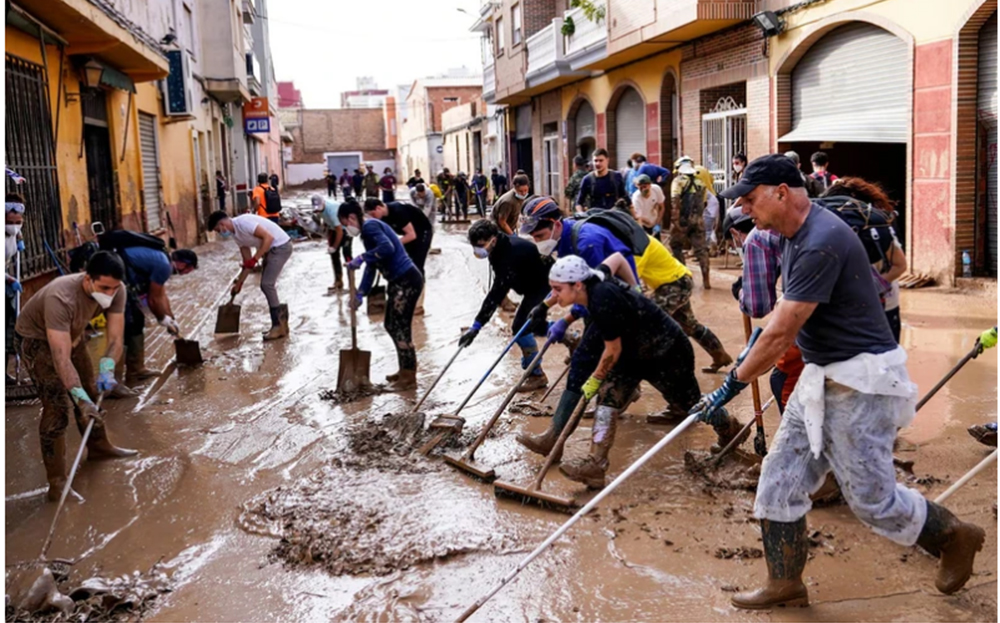 Người dân dọn dẹp bùn sau lũ lụt ở Massanassa, Valencia.