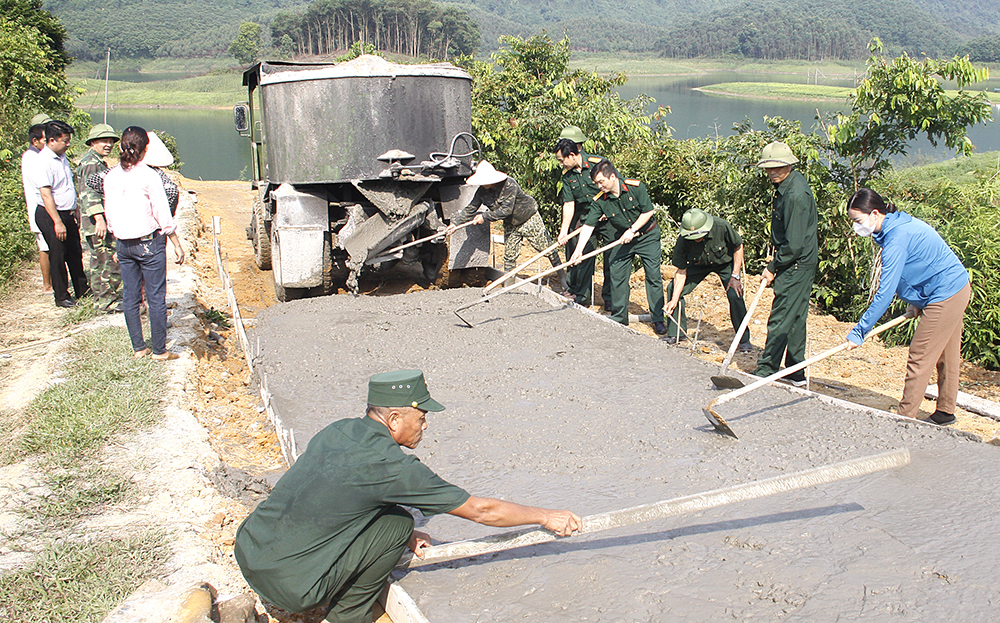 Cán bộ, hội viên cựu chiến binh và người dân thôn Làng Na, xã Phúc Ninh thi công đổ bê tông tuyến đường giao thông ra bến tàu khách.