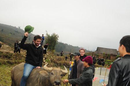 Du khách nước ngoài thích thú cưỡi trâu khi thăm làng bản Sa Pa.