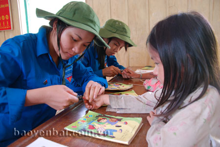 Thanh niên tình nguyện giúp đỡ học sinh vùng cao trong cuộc sống và học tập.
