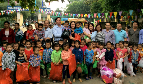 Giám đốc Kho bạc nhà nước Yên Bái Bùi Văn Đinh tặng quà cho các cháu Trường Mầm non Bình Minh, xã Động Quan (Lục Yên).