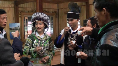 Cô dâu, chú rể người dân tộc Mông (Trạm Tấu) nhận chén rượu chúc phúc từ người thân trong gia đình.