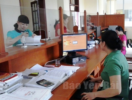 Bộ phận một cửa Chi cục Thuế huyện Yên Bình hướng dẫn người nộp thuế  thực hiện chính sách thuế.

