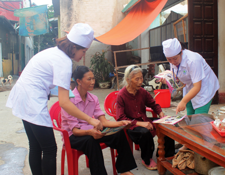 Cán bộ Trung tâm Y tế thành phố Yên Bái và phường Nguyễn Thái Học phát tờ rơi, tuyên truyền phòng chống sốt xuất huyết tới người dân.