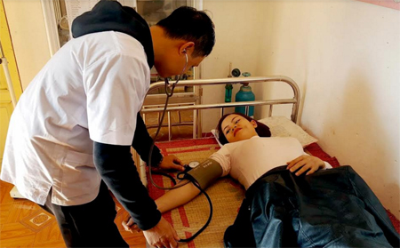 Cán bộ Phòng khám Đa khoa khu vực Sơn Lương khám bệnh cho người dân.