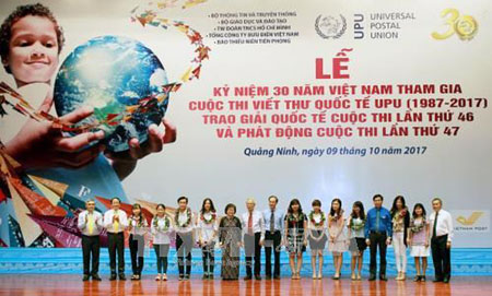 Ban Tổ chức trao vòng nguyệt quế cho các em học sinh đoạt giải trong cuộc thi Viết thư Quốc tế UPU tại Lễ kỷ niệm 30 năm ngày Việt Nam.
