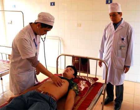 Bác sỹ TTYT huyện Yên Bình thăm khám cho bệnh nhân điều trị nội trú.