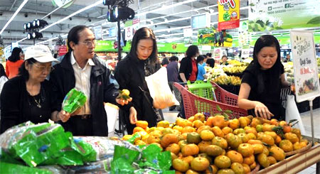 Người dân đến tham quan, mua sắm tại gian hàng trưng bày sản phẩm quýt sen Văn Chấn tại Siêu thị Big C Thăng Long, Hà Nội.